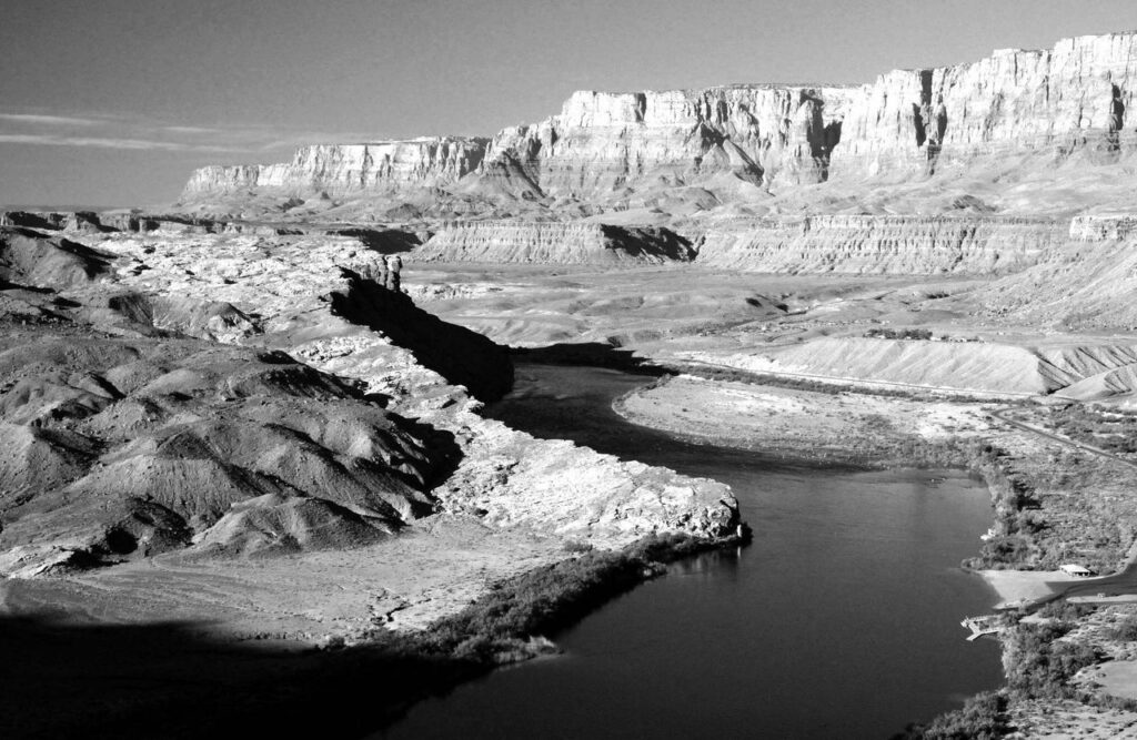Stunning black and white view of a river winding through the Grand Canyon's majestic landscape.