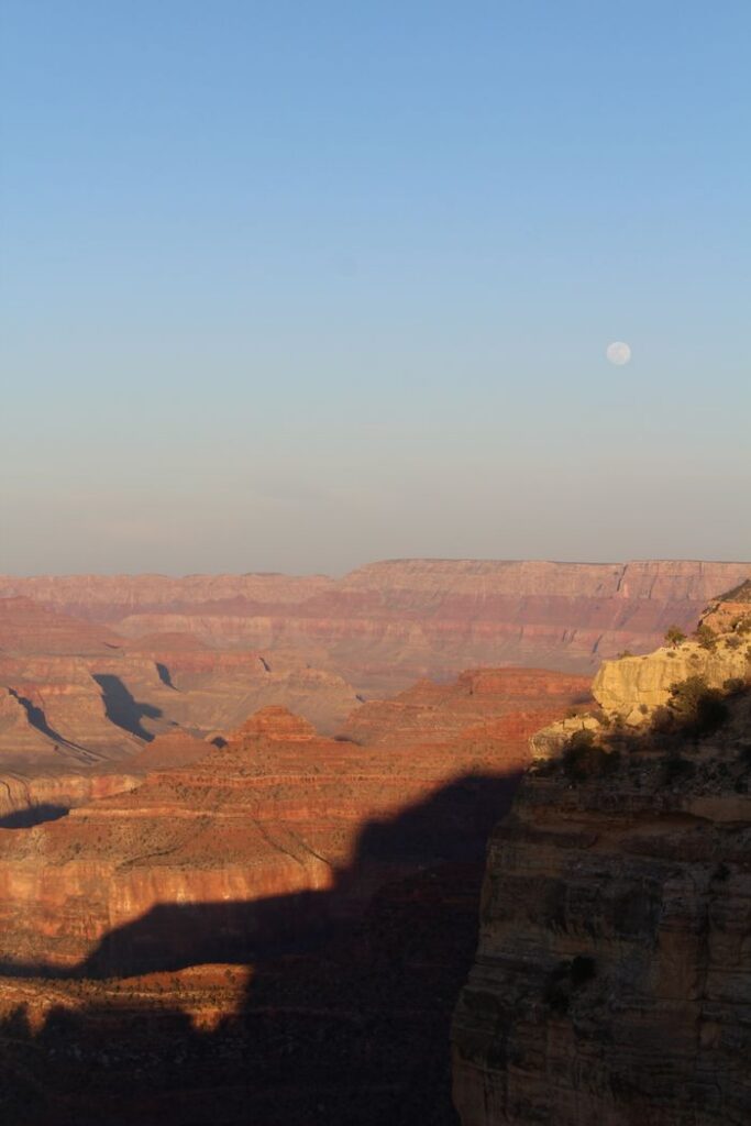 Scenic view of the Grand Canyon with moonlit sky, showcasing natural beauty during golden hour.